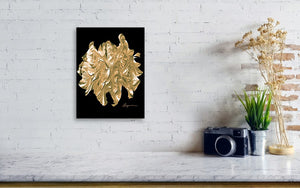 a white brick wall with a black and gold painting on it